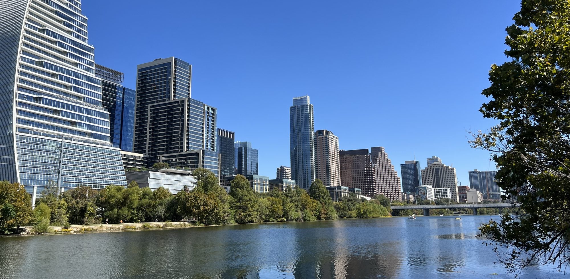 Downtown Austin high-rises along Lady Bird Lake under a clear blue sky