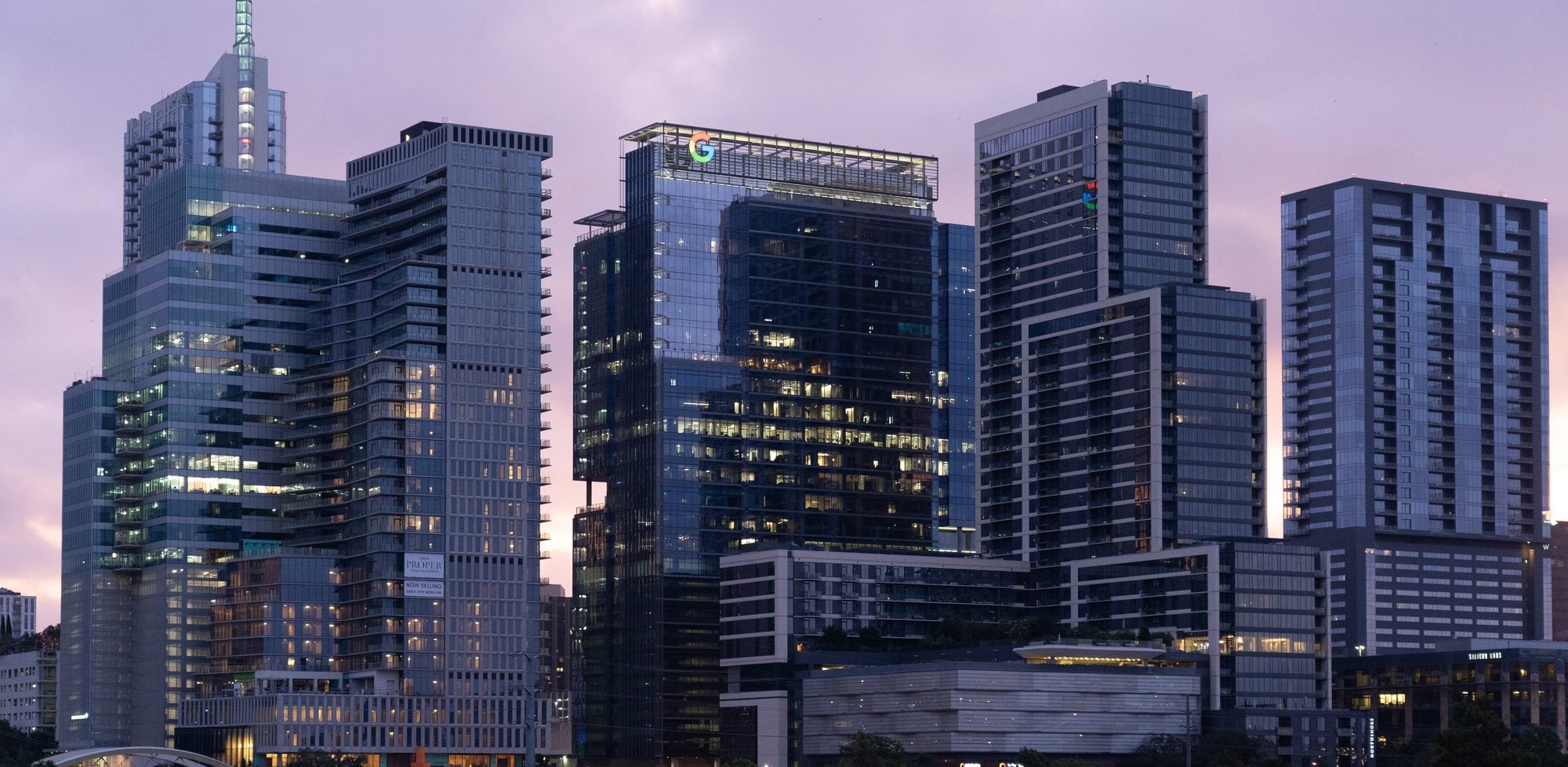 Downtown Austin high-rises at sunrise under a pink and purple sky