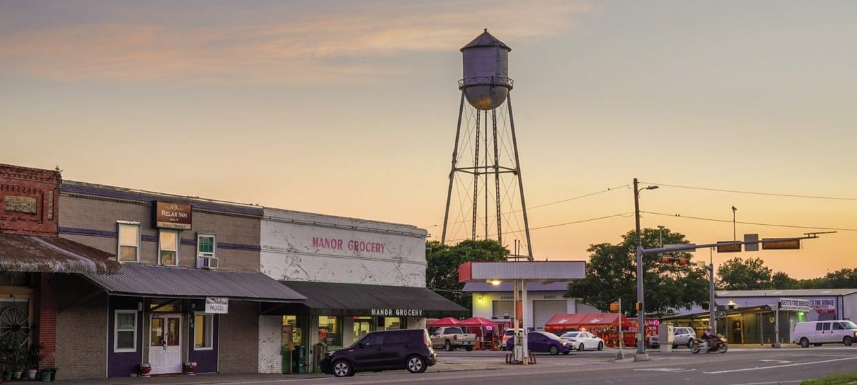 Downtown Manor at sunset, with the historic water tower behind Manor Grocery