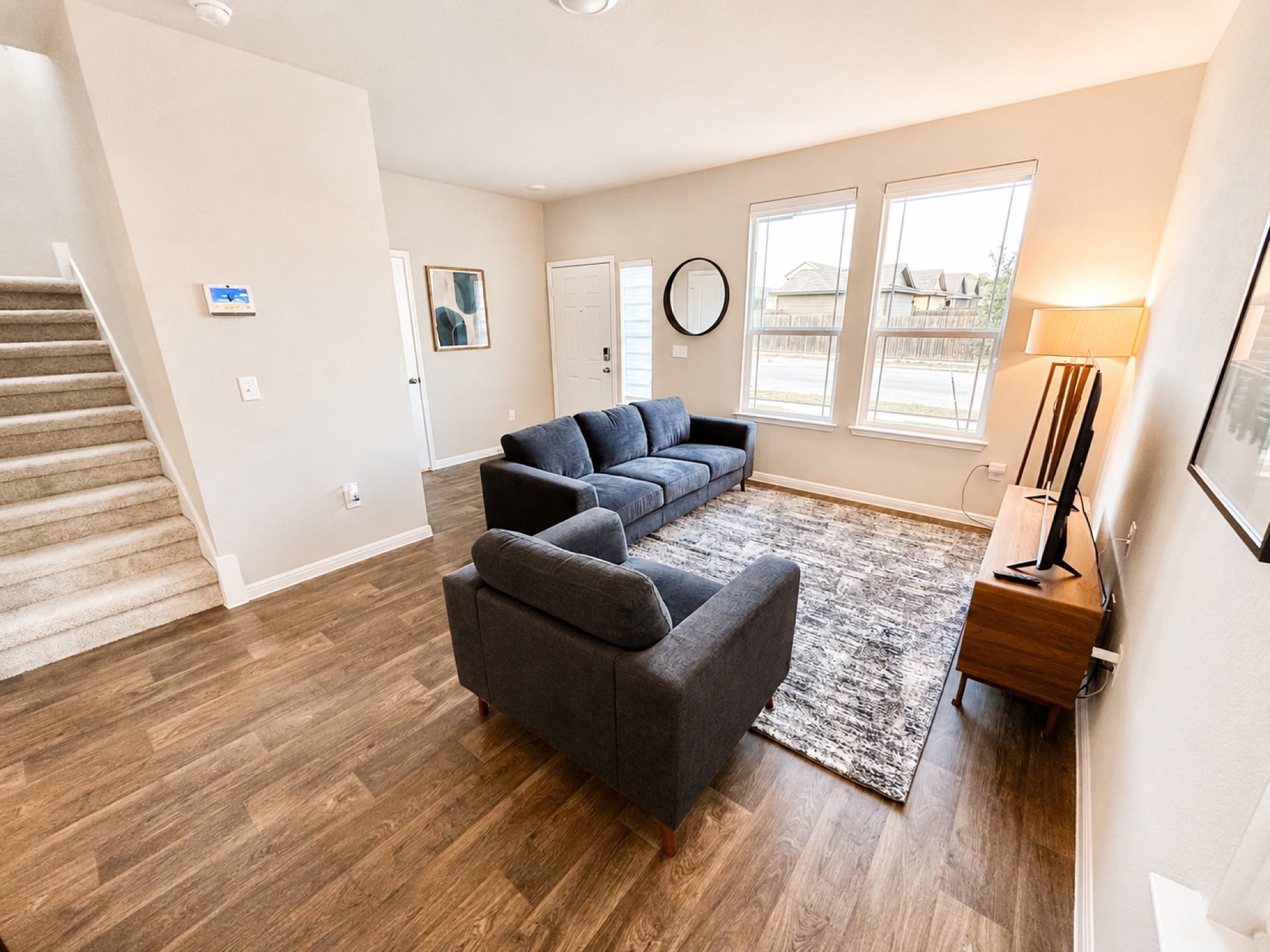 Furnished living room at Arborside with two sofas and a staircase