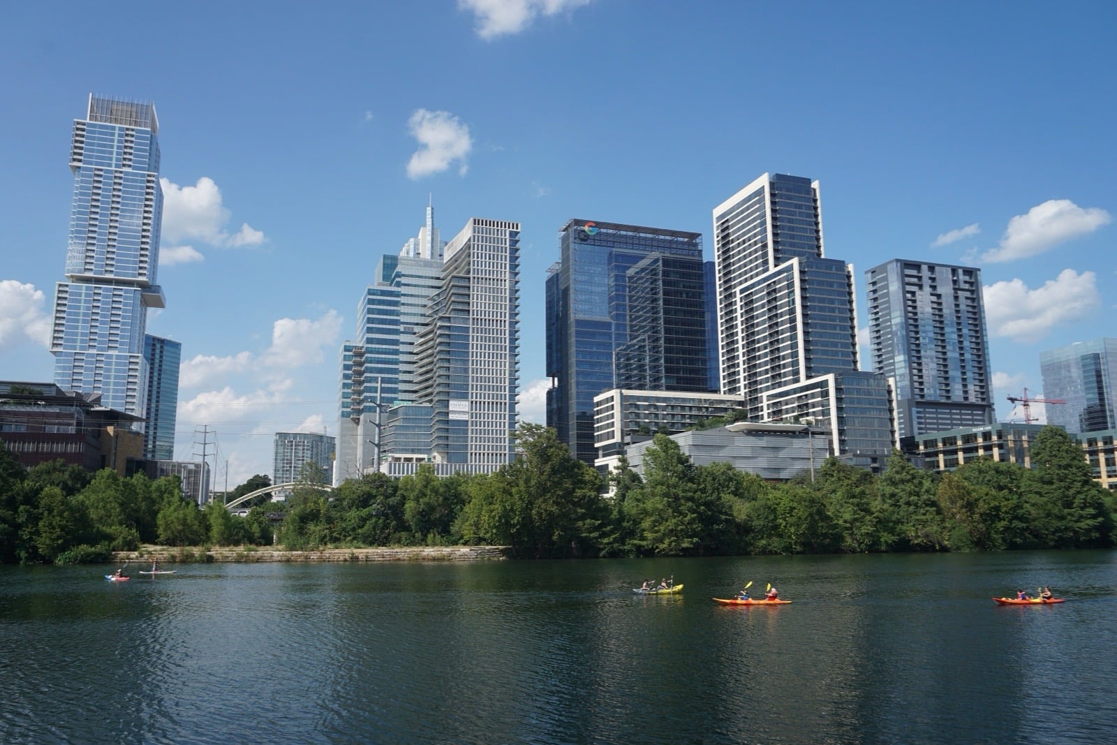 Downtown Austin high-rises across Lady Bird Lake, with kayakers on the water